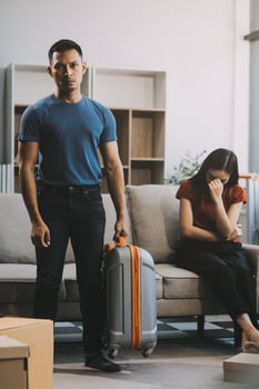 Family couple ignoring each other after a quarrel. Two people turn away and don't talk to each other. Angry young man and woman sitting back to back, with arms crossed on the sofa in the living room photo