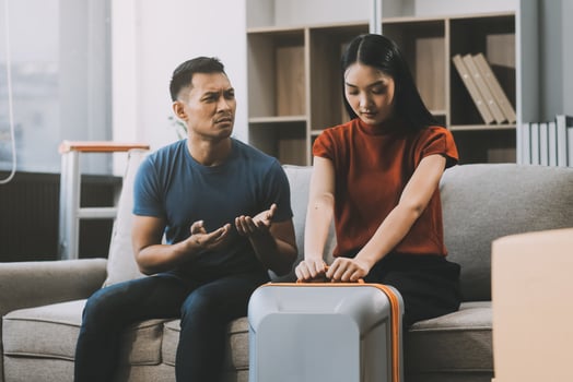 Family couple ignoring each other after a quarrel. Two people turn away and don't talk to each other. Angry young man and woman sitting back to back, with arms crossed on the sofa in the living room photo