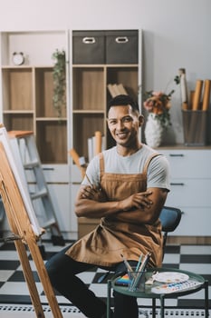Young male artist painting picture in studio photo