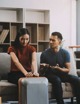 Family couple ignoring each other after a quarrel. Two people turn away and don't talk to each other. Angry young man and woman sitting back to back, with arms crossed on the sofa in the living room photo