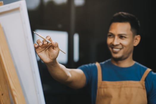 Young male artist painting picture in studio photo