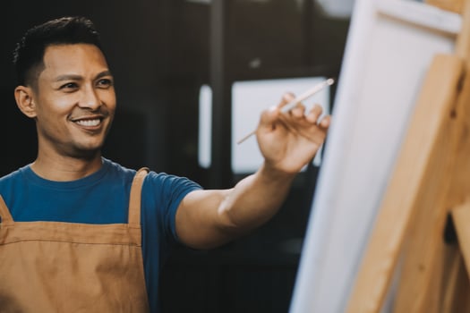 Young male artist painting picture in studio photo