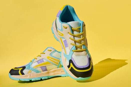 Fashionable Sneakers on yellow background. Creative banner with stylish shoes photo
