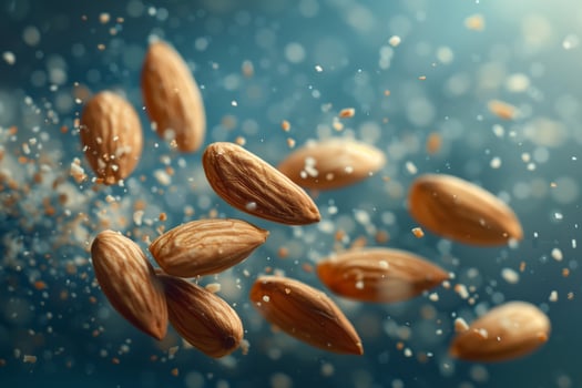 Almonds falling in air on blue background photo