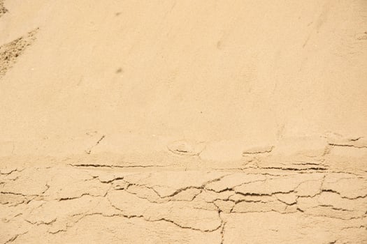 A close-up image of tan sand with visible cracks photo