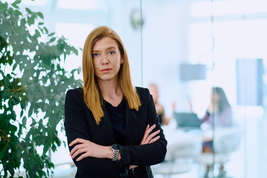 Portrait of a Blonde Businesswoman in a Modern Office with Her Workspace and Colleagues in the Background. photo