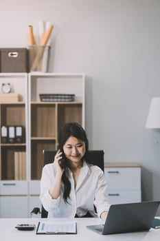Attractive asian woman using a laptop PC and a smart phone. photo