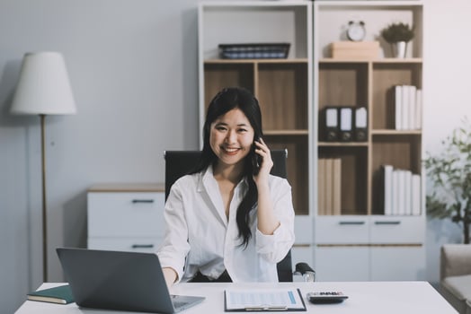 Attractive asian woman using a laptop PC and a smart phone. photo