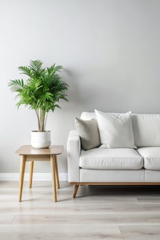 Minimalist Living Room. A white couch with a white pillow on it and a plant on the side table. photo
