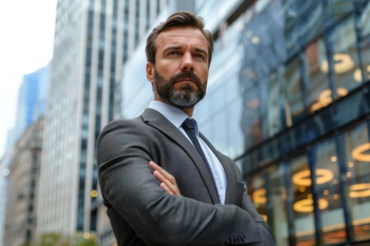 Professional man in suit posing with arms crossed, skyscrapers in the background photo