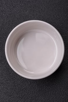 Beautiful empty white ceramic gravy boat on a concrete background photo