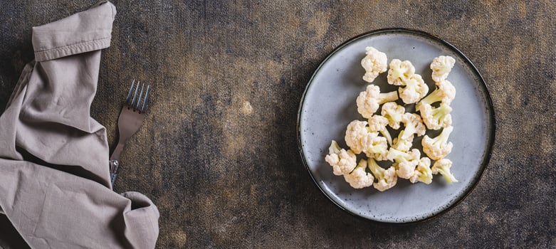 Vegetarian vegetable raw cauliflower on a plate on the table top view web banner photo