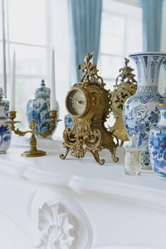 luxury interior decor. vintage clock and antique vases on fireplace. royal house photo