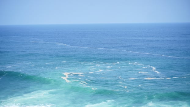 Front view over the ocean and white foam waves. Feel calm, cool, relaxed. Idea for cool background and copy space above. photo