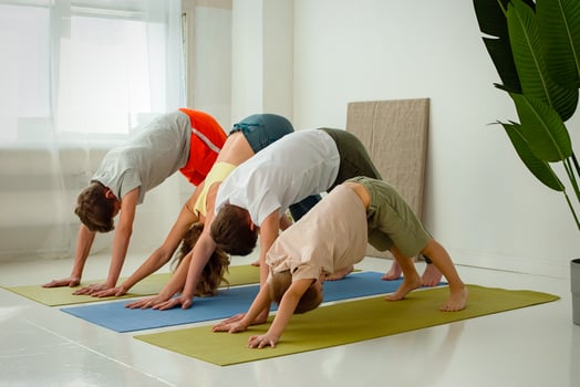 a boy, two teenagers and woman, perform a yoga exercise, on mats photo