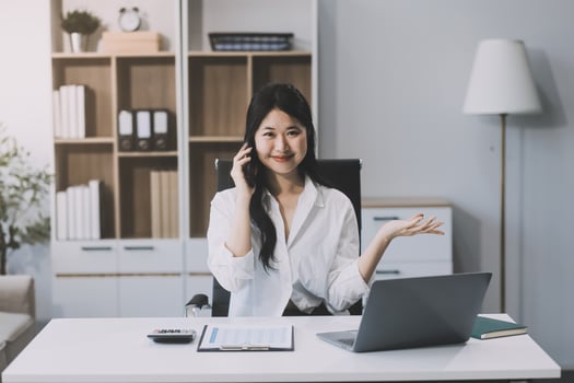 Attractive asian woman using a laptop PC and a smart phone. photo