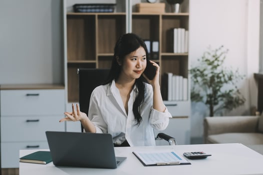 Attractive asian woman using a laptop PC and a smart phone. photo