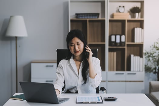 Attractive asian woman using a laptop PC and a smart phone. photo