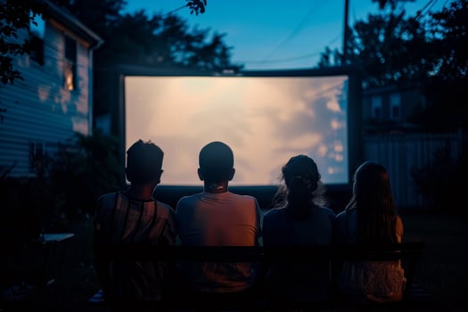 people are sitting in lawn chairs in front of a large screen photo