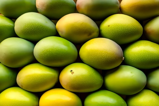 A bunch of fresh raw green mangoes are arranged is stack and forming a background photo