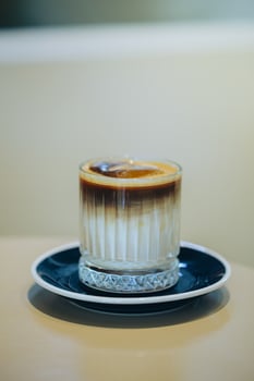 Elegant layered coffee in a clear glass, highlighting rich textures. photo