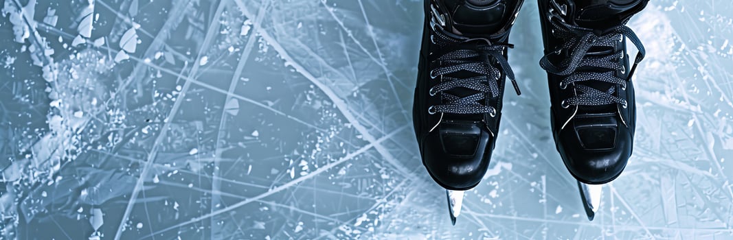 Photo of Black hockey skates and stick on ice rink background, top view with copy space banner for design element.