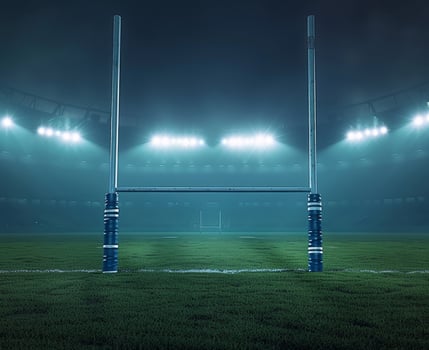Illuminated rugby stadium at night with goalpost in foreground, showcasing the atmosphere of game day under bright floodlights. photo