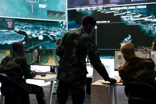 Army recruit conducting an intelligence gathering activity in control room, working on anti terrorism defense plan. Trooper collecting all important data from surveillance footage on big screen. photo