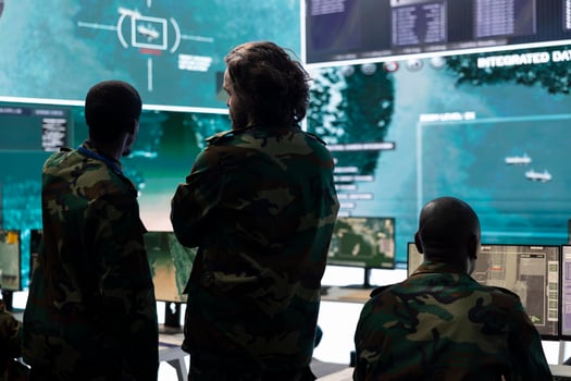 Military personnel discussing about enemy vessel trajectory in control room, analyzing data for defense program mission in command center. Army staff gathering intelligence from big screen. photo