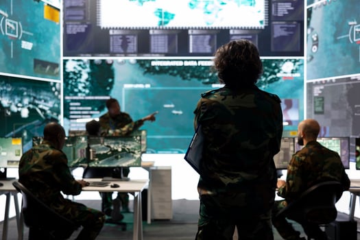 Intelligence analyst supervising and coordinating in the federal data analysis, processing strategic and tactical information to create a new battlefield world map. Military division in control room. photo
