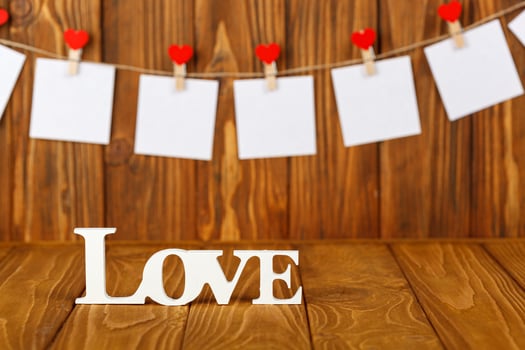 white pieces of paper on clothespins with a heart on a wooden background, a wooden inscription I love you photo