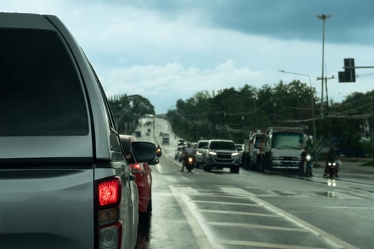 Rear side of pickup car with pickup truck roof. Turn on brake light on aspaht road with wet of rain. Cars were waiting for the traffic lights at the intersection. photo