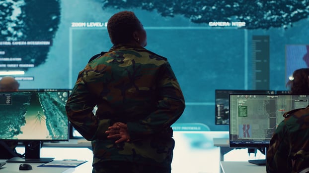 Woman army officer coordinating special operations mission in command post, monitoring surveillance satellite footage on big screen in military power base. Female soldier on duty. Camera A. photo