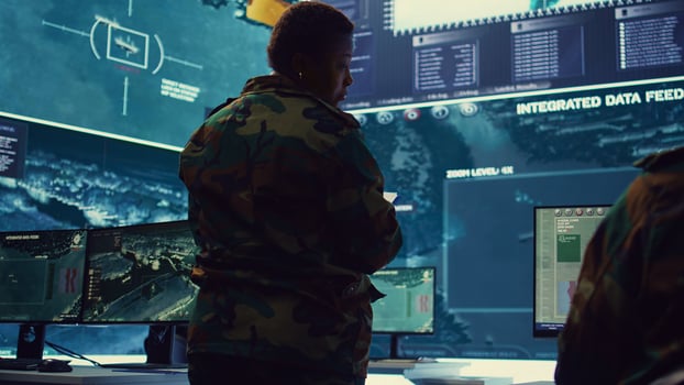 Female brigadier general gather intelligence reports on a big screen, ensuring national safety. Overseeing planning and coordination for a special mission, military reconnaissance system. Camera B. photo