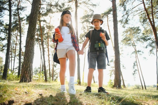 Little boy and girl go hiking on a forest road photo