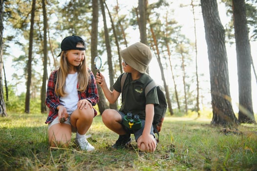 boy and girl go hiking with backpacks on forest road bright sunny day photo