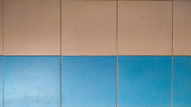 walls with square-shaped blue and orange ceramic tiles that decorate the walls in the bathroom photo