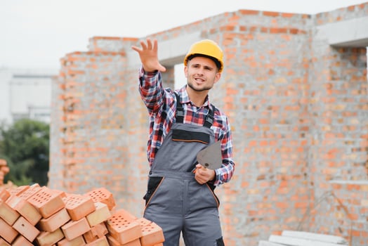 Yellow colored hard hat. Young man working in uniform at construction at daytime. photo