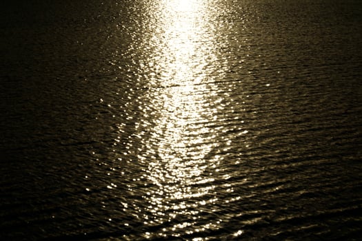 Sun reflecting in water surface at sunset photo