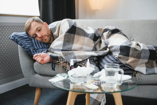 Sick man lying on sofa at home. photo