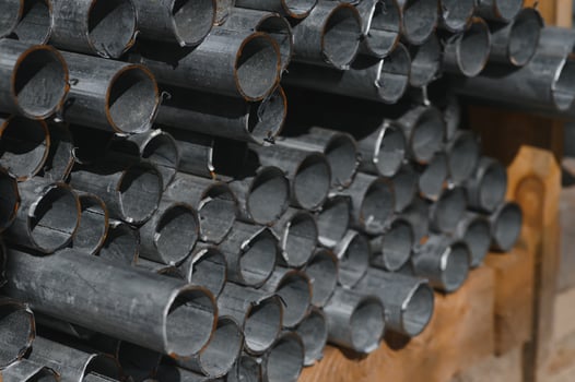 Metal profile pipe of round section in packs at the warehouse of metal products. photo
