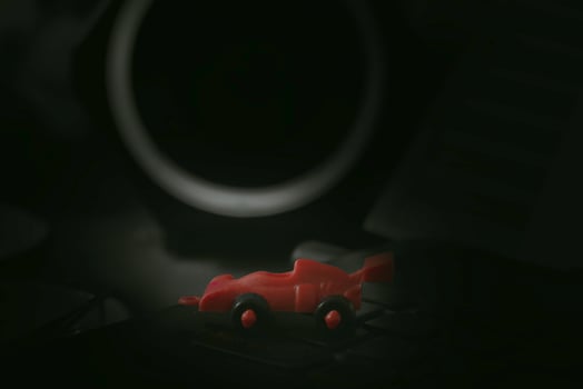 Red toy racing car. Dark scene. photo