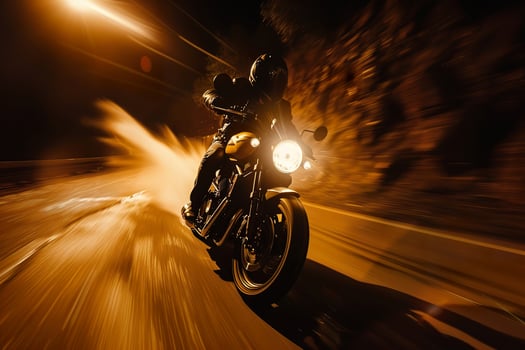 A motorcycle is speeding down a road with a splash of water behind it photo