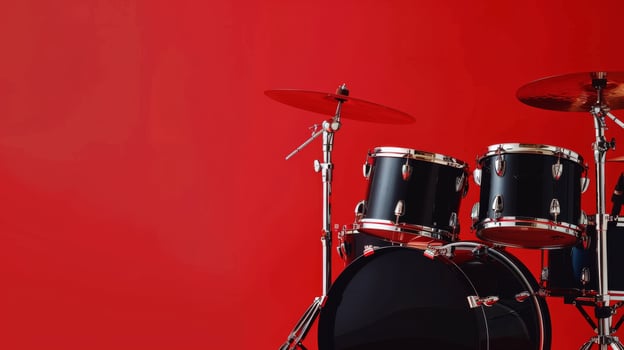 A close-up of a black drum set with cymbals against a red background photo