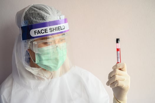 Nurse wearing PPE suit for protect coronavirus disease and holding a sample test tube with blood for 2019-nCoV analyzing. Conceptual of laboratory testing for the respiratory coronavirus disease 2019. photo