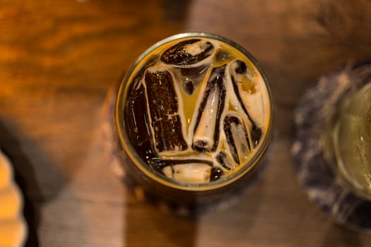 A glass ice black coffee or Americano on wood table, night club atmosphere photo
