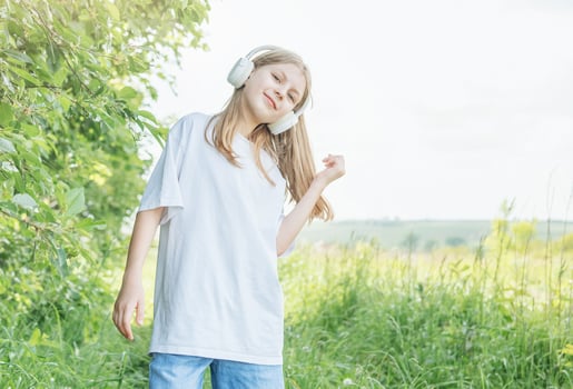 A child with headphones listening to music and dancing photo