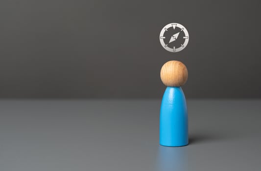 A man with a compass over his head. Navigation and personal goals. Follow your guidelines. Determining the goal and reconnoitering the path to it. Follows a business compass benchmark photo
