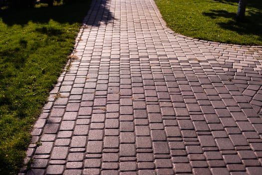 Cobblestone road in the park in autumn and green trees in background photo