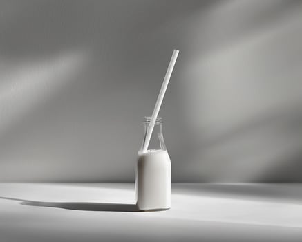 a bottle of milk with a straw on a table photo